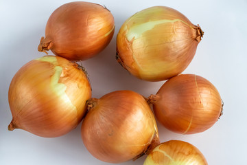 Yellow onion on white background. A pile of raw onions close-up. Top view.