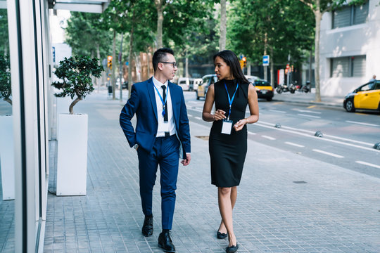 Stylish Coworkers Chatting While Walking On Street