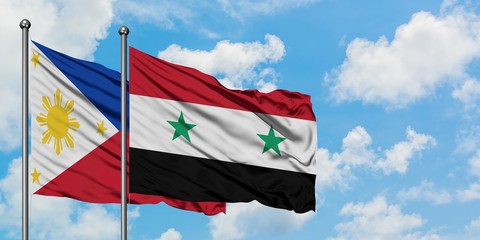Philippines and Syria flag waving in the wind against white cloudy blue sky together. Diplomacy concept, international relations.