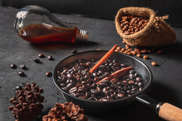 .Raw coffee beans in sack bags and roasted coffee beans in a pan on a black background.