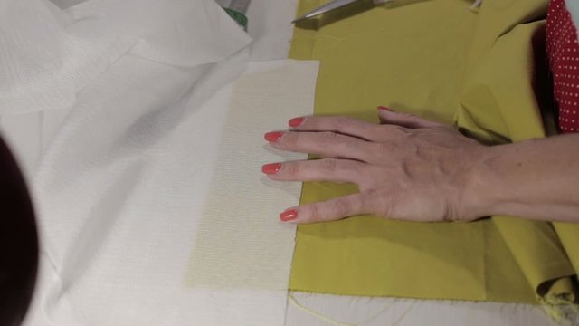 girl reveals and measures fabric for sewing