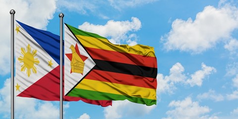 Philippines and Zimbabwe flag waving in the wind against white cloudy blue sky together. Diplomacy concept, international relations.
