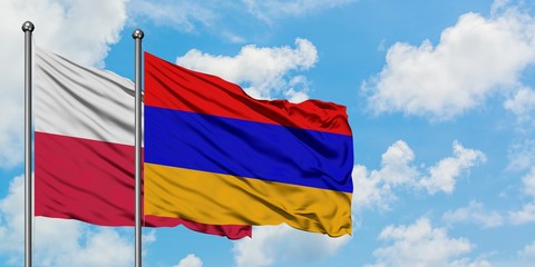 Poland and Armenia flag waving in the wind against white cloudy blue sky together. Diplomacy concept, international relations.