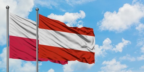 Poland and Austria flag waving in the wind against white cloudy blue sky together. Diplomacy concept, international relations.