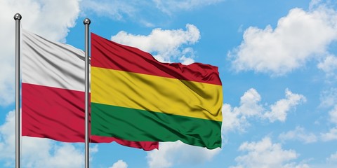 Poland and Bolivia flag waving in the wind against white cloudy blue sky together. Diplomacy concept, international relations.
