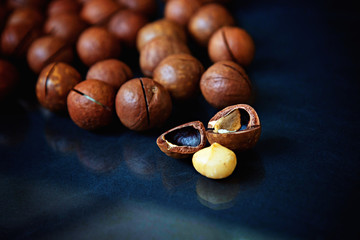 Unpeeled macadamia nuts laying on blue cloth