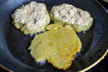 potato pancakes are fried in a pan, boiling oil