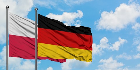 Poland and Germany flag waving in the wind against white cloudy blue sky together. Diplomacy concept, international relations.