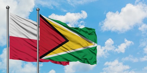 Poland and Guyana flag waving in the wind against white cloudy blue sky together. Diplomacy concept, international relations.