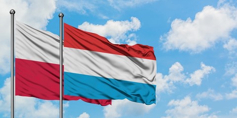 Poland and Luxembourg flag waving in the wind against white cloudy blue sky together. Diplomacy concept, international relations.