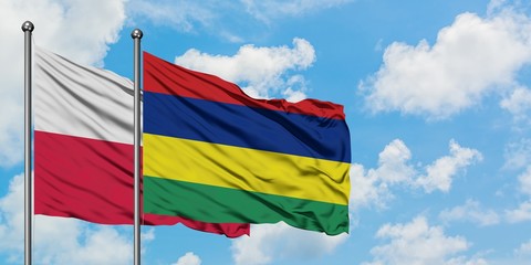 Poland and Mauritius flag waving in the wind against white cloudy blue sky together. Diplomacy concept, international relations.