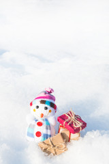 snowman with gifts on snow with space for text. vertical.