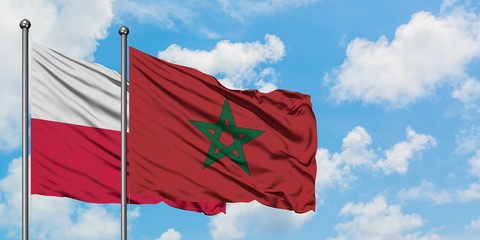Poland and Morocco flag waving in the wind against white cloudy blue sky together. Diplomacy concept, international relations.