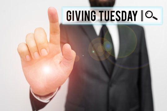 Text sign showing Giving Tuesday. Business photo showcasing international day of charitable giving Hashtag activism Male human with beard wear formal working suit clothes raising one hand up