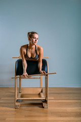 Beautiful woman doing pilates exercise, training on barrels. Fitness concept, special fitness equipment, healthy lifestyle, plastic. Copy space, sport banner for advertising.