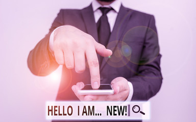 Text sign showing Hello I Am New. Business photo text introducing oneself in a group as fresh worker or student Male human wear formal work suit hold smart hi tech smartphone use one hand © Zofia