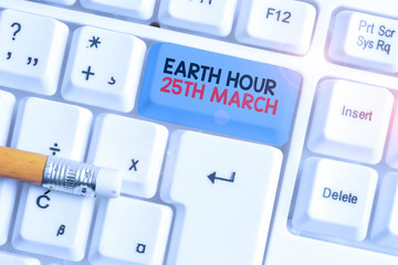 Writing note showing Earth Hour 25Th March. Business concept for symbol commitment to planet Organized World Wide Fund White pc keyboard with note paper above the white background
