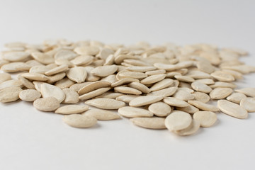 Roasted pumpkin seeds with salt on white background.