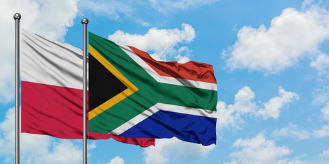 Poland and South Africa flag waving in the wind against white cloudy blue sky together. Diplomacy concept, international relations.