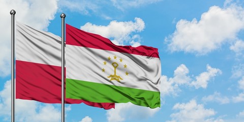 Poland and Tajikistan flag waving in the wind against white cloudy blue sky together. Diplomacy concept, international relations.