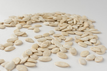Roasted pumpkin seeds with salt on white background.