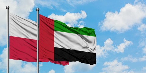 Poland and United Arab Emirates flag waving in the wind against white cloudy blue sky together. Diplomacy concept, international relations.