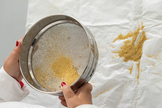 Female pharmacist sifting chamomile through bolter close up