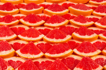 Grapefruit red juicy slices background. top view.