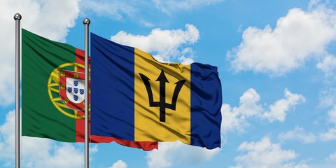 Portugal and Barbados flag waving in the wind against white cloudy blue sky together. Diplomacy concept, international relations.