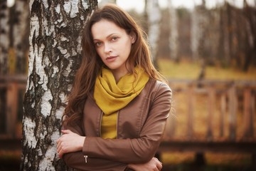 Outdoors portrait of a pretty woman in the autumn park