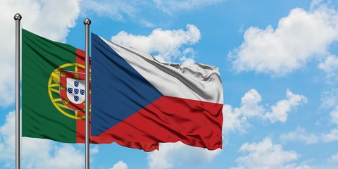 Portugal and Czech Republic flag waving in the wind against white cloudy blue sky together. Diplomacy concept, international relations.