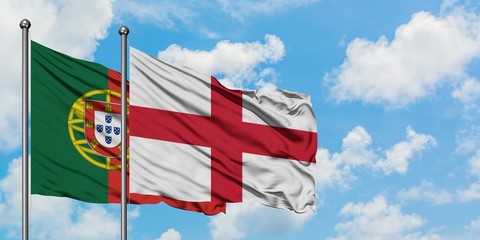 Portugal and England flag waving in the wind against white cloudy blue sky together. Diplomacy concept, international relations.