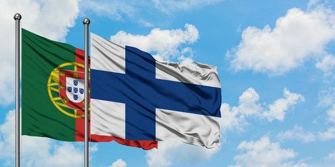 Portugal and Finland flag waving in the wind against white cloudy blue sky together. Diplomacy concept, international relations.