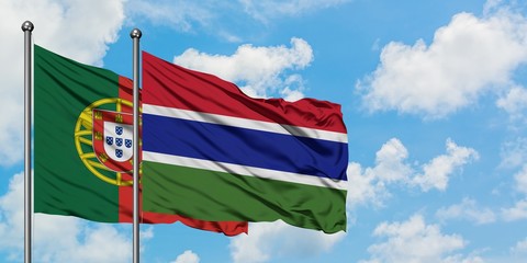Portugal and Gambia flag waving in the wind against white cloudy blue sky together. Diplomacy concept, international relations.