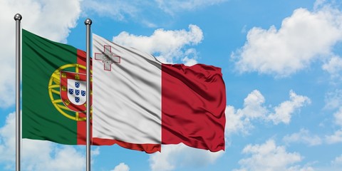 Portugal and Malta flag waving in the wind against white cloudy blue sky together. Diplomacy concept, international relations.