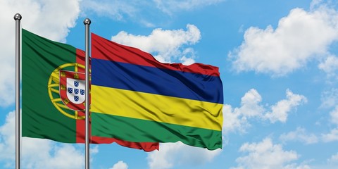 Portugal and Mauritius flag waving in the wind against white cloudy blue sky together. Diplomacy concept, international relations.