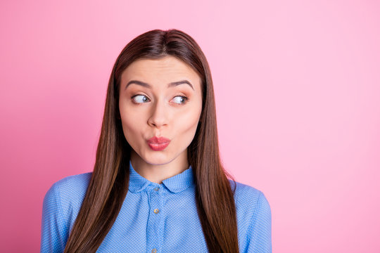 Close up photo of cute sweet lady staring curiously wearing blue shirt isolated over pink pastel background