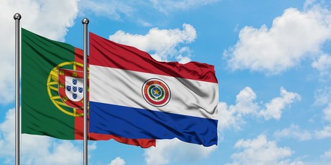 Portugal and Paraguay flag waving in the wind against white cloudy blue sky together. Diplomacy concept, international relations.