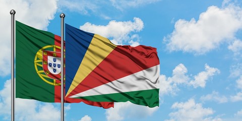 Portugal and Seychelles flag waving in the wind against white cloudy blue sky together. Diplomacy concept, international relations.
