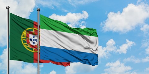 Portugal and Sierra Leone flag waving in the wind against white cloudy blue sky together. Diplomacy concept, international relations.