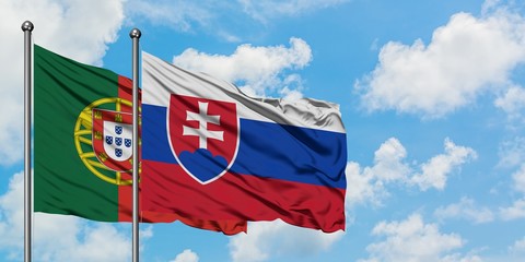 Portugal and Slovakia flag waving in the wind against white cloudy blue sky together. Diplomacy concept, international relations.