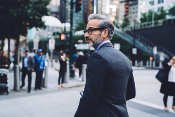 Half turned middle aged male in costume looking away on street