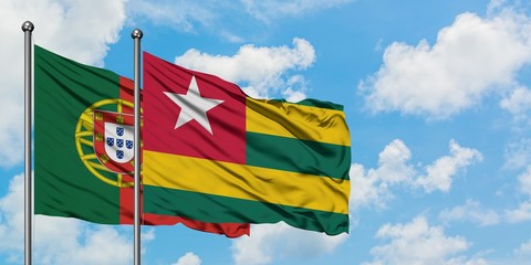 Portugal and Togo flag waving in the wind against white cloudy blue sky together. Diplomacy concept, international relations.