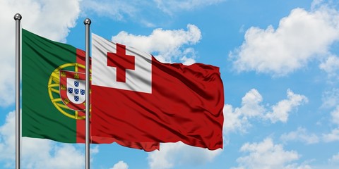 Portugal and Tonga flag waving in the wind against white cloudy blue sky together. Diplomacy concept, international relations.