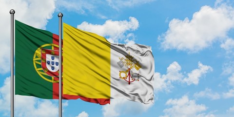 Portugal and Vatican City flag waving in the wind against white cloudy blue sky together. Diplomacy concept, international relations.