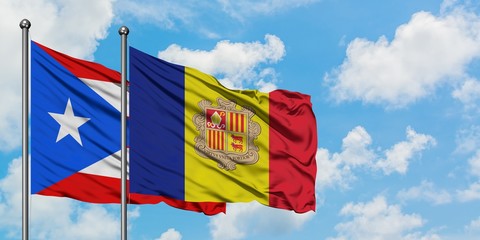 Puerto Rico and Andorra flag waving in the wind against white cloudy blue sky together. Diplomacy concept, international relations.