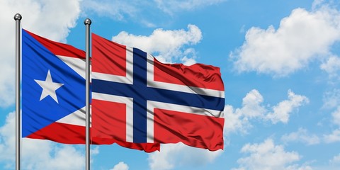 Puerto Rico and Bouvet Islands flag waving in the wind against white cloudy blue sky together. Diplomacy concept, international relations.