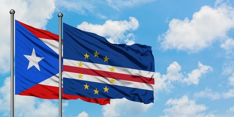 Puerto Rico and Cape Verde flag waving in the wind against white cloudy blue sky together. Diplomacy concept, international relations.