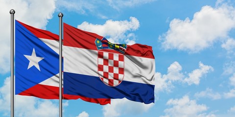 Puerto Rico and Croatia flag waving in the wind against white cloudy blue sky together. Diplomacy concept, international relations.