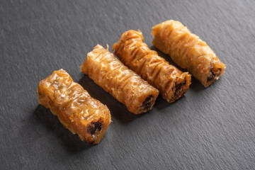 Traditional greek pastries saragli on dark background
